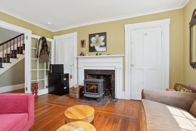 living area with a wood stove, crown molding, stairway, and baseboards