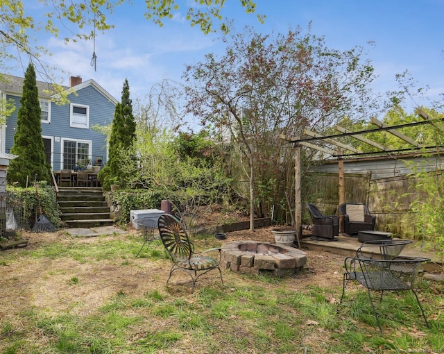view of yard featuring an outdoor fire pit, fence, stairway, and a deck
