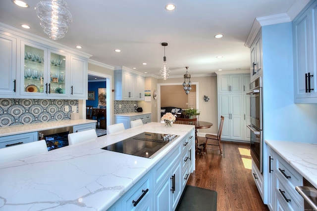 11 Tall Pines Dr, Weston, CT 06833 - kitchen with black electric stovetop, stainless steel double oven, dark wood-style flooring, backsplash, and pendant lighting