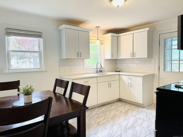 158 Louisiana Ave, Bridgeport, CT 06610 - kitchen with a sink, light countertops, decorative backsplash, and white cabinetry