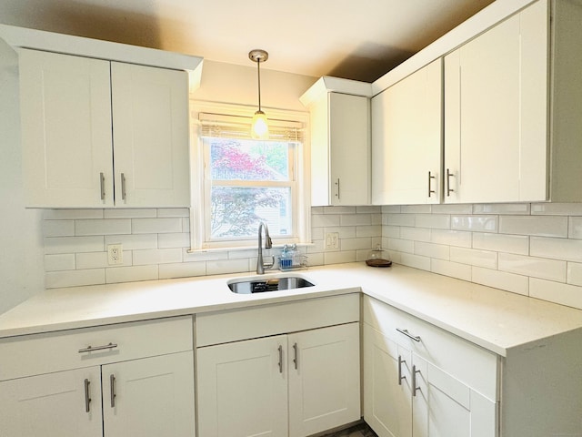 158 Louisiana Ave, Bridgeport, CT 06610 - kitchen featuring a sink, white cabinetry, pendant lighting, decorative backsplash, and light countertops