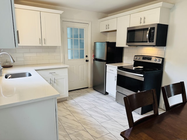 158 Louisiana Ave, Bridgeport, CT 06610 - kitchen with stainless steel appliances, a sink, light marble finish flooring, and white cabinets