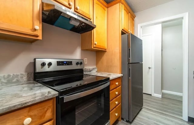 kitchen featuring under cabinet range hood, light wood finished floors, light stone countertops, baseboards, and appliances with stainless steel finishes