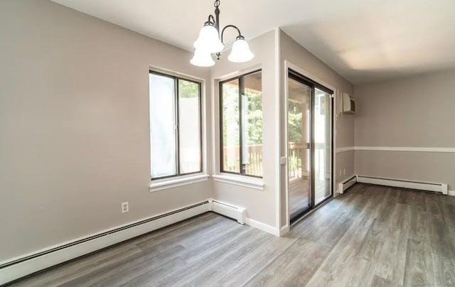unfurnished dining area with wood finished floors, a baseboard radiator, a chandelier, baseboard heating, and baseboards