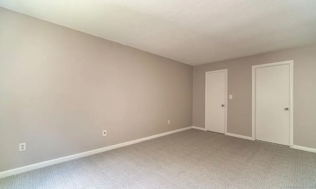 empty room with light colored carpet and baseboards