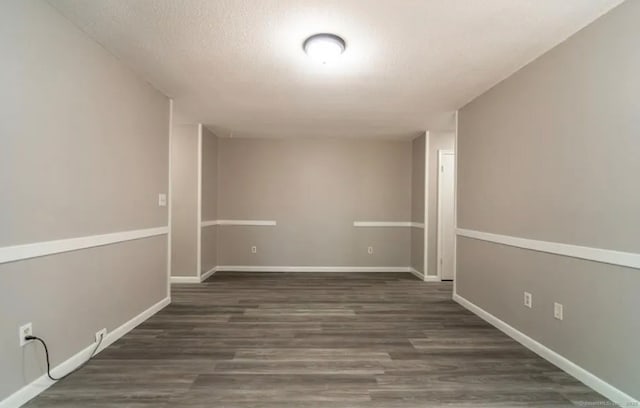 basement with a textured ceiling, baseboards, and wood finished floors
