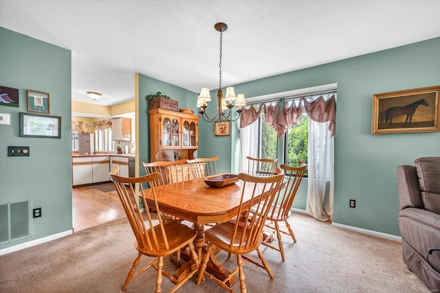dining space with a chandelier, light carpet, baseboards, and a textured ceiling