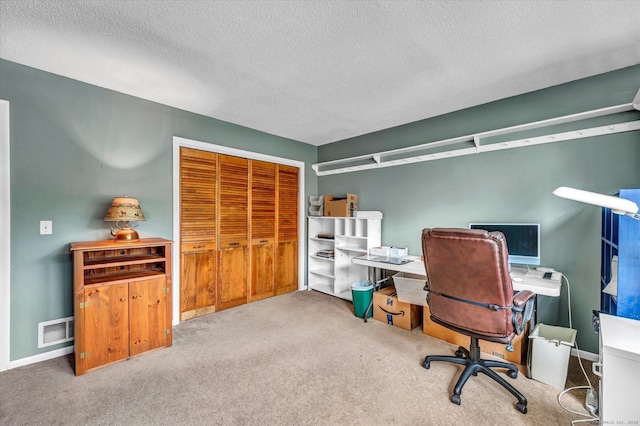 office space featuring carpet, a textured ceiling, and baseboards