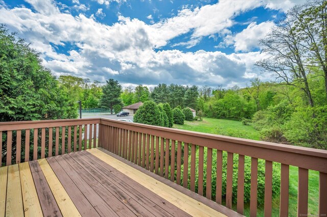 wooden terrace featuring a lawn