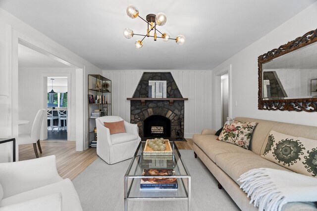 227 Sugar St, Newtown, CT 06470 - living area with a chandelier, wood finished floors, and a stone fireplace