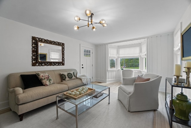 227 Sugar St, Newtown, CT 06470 - living area featuring wood finished floors, a chandelier, and baseboards