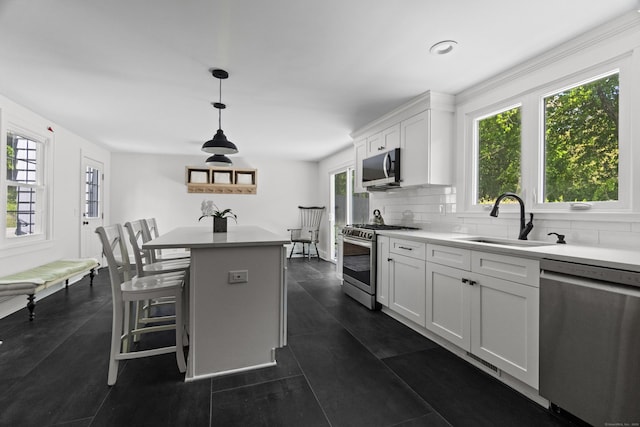 227 Sugar St, Newtown, CT 06470 - kitchen with stainless steel appliances, a sink, decorative backsplash, a kitchen island, and white cabinets