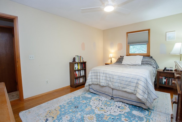 bedroom with baseboards, a ceiling fan, and wood finished floors