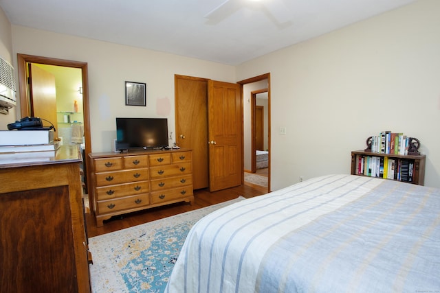bedroom featuring ceiling fan, connected bathroom, and wood finished floors