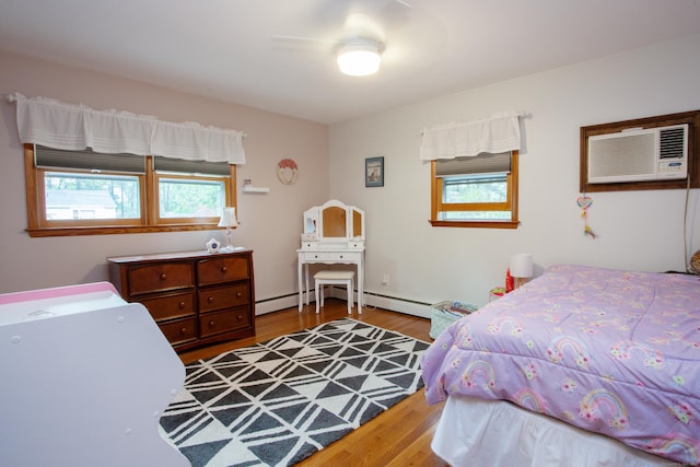 bedroom featuring a ceiling fan, multiple windows, wood finished floors, and an AC wall unit