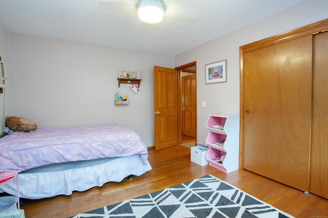 bedroom with a closet, wood finished floors, and ceiling fan