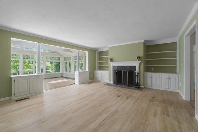 157 Pine Lake Rd, Westbrook, CT 06498 - unfurnished living room featuring built in shelves, light wood-type flooring, a fireplace, and crown molding