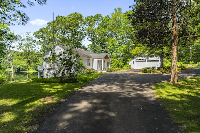 157 Pine Lake Rd, Westbrook, CT 06498 - view of front facade featuring an outbuilding, a front lawn, asphalt driveway, a chimney, and a water view