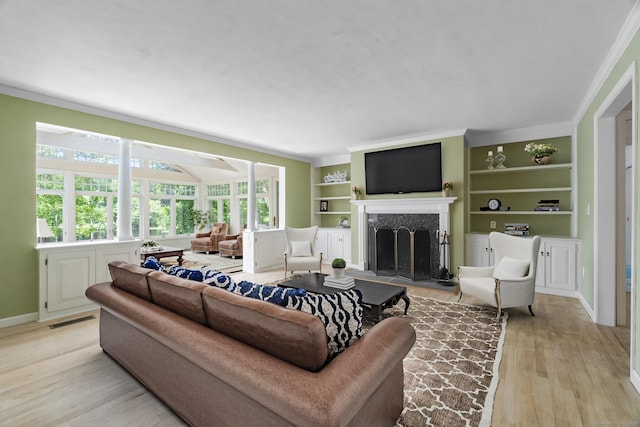 157 Pine Lake Rd, Westbrook, CT 06498 - living area featuring light wood-style flooring, a premium fireplace, ornamental molding, and built in shelves
