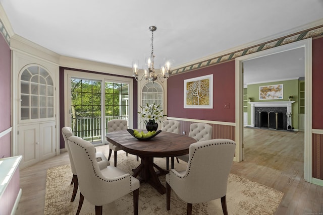 157 Pine Lake Rd, Westbrook, CT 06498 - dining room featuring a chandelier, light wood-style flooring, ornamental molding, a premium fireplace, and wainscoting