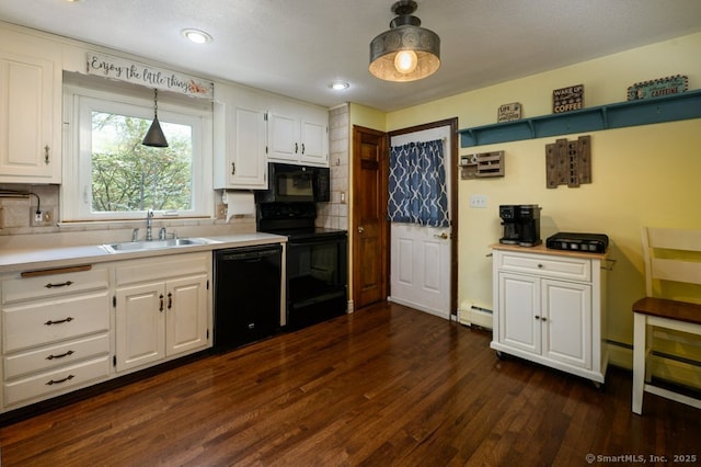 kitchen featuring black appliances, a sink, baseboard heating, decorative backsplash, and white cabinetry
