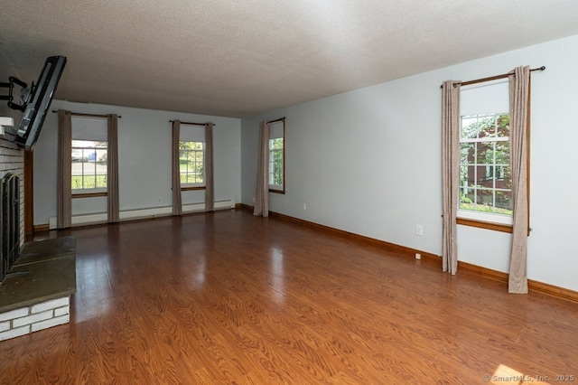 unfurnished living room with a fireplace, a baseboard radiator, wood finished floors, a textured ceiling, and baseboards