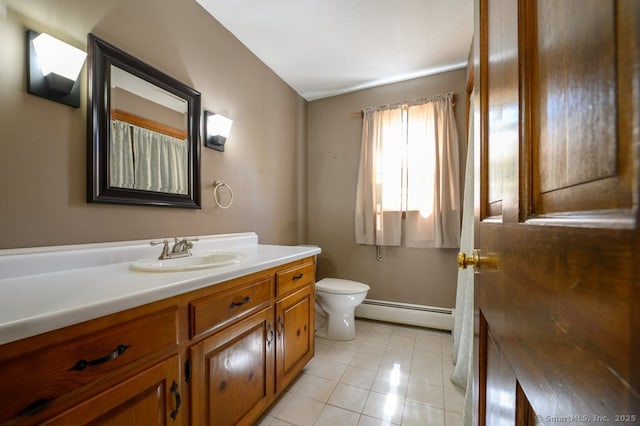bathroom with baseboard heating, tile patterned floors, toilet, and vanity