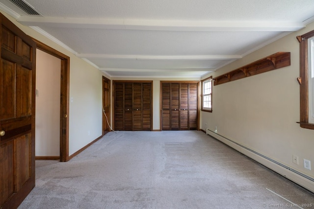 empty room featuring baseboard heating, beam ceiling, light colored carpet, and baseboards