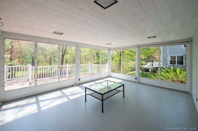 unfurnished sunroom featuring plenty of natural light and finished concrete floors