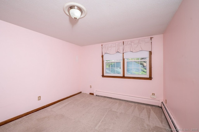 carpeted spare room featuring baseboard heating, a baseboard radiator, and baseboards