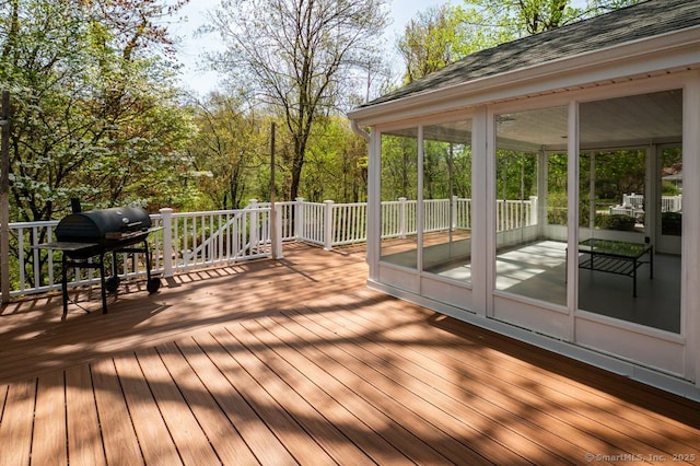 deck featuring a sunroom and area for grilling
