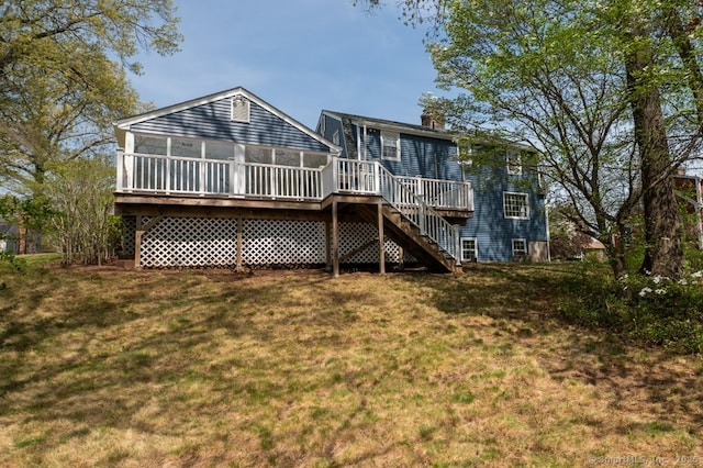 rear view of property with a yard, a chimney, a sunroom, a wooden deck, and stairs