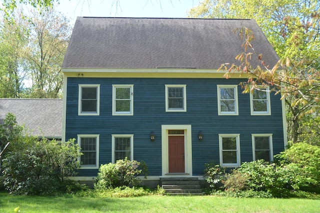 colonial home featuring entry steps and a shingled roof