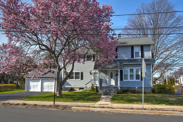 6 Thompson St, Fairfield, CT 06825 - view of front of home featuring asphalt driveway, a front yard, a garage, a chimney, and a shingled roof