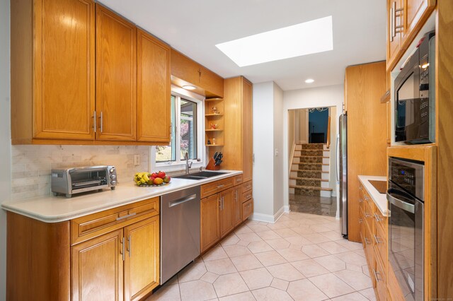 6 Shadow Ln, Norwalk, CT 06851 - kitchen featuring stainless steel appliances, a sink, a skylight, light countertops, and baseboards
