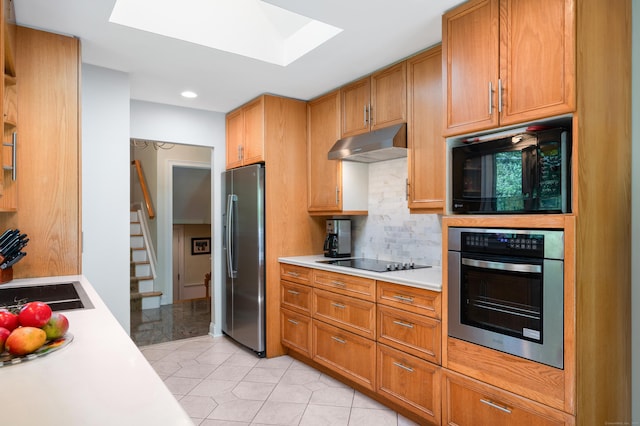 6 Shadow Ln, Norwalk, CT 06851 - kitchen with black appliances, under cabinet range hood, a skylight, light countertops, and backsplash