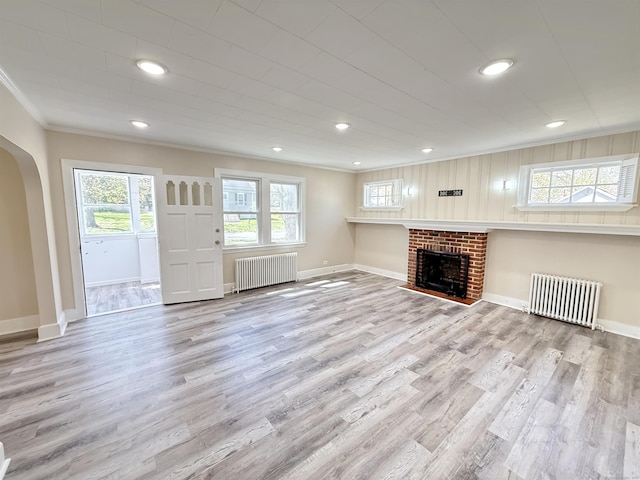 815 Alling Rd, Orange, CT 06477 - unfurnished living room with radiator, arched walkways, wood finished floors, crown molding, and baseboards