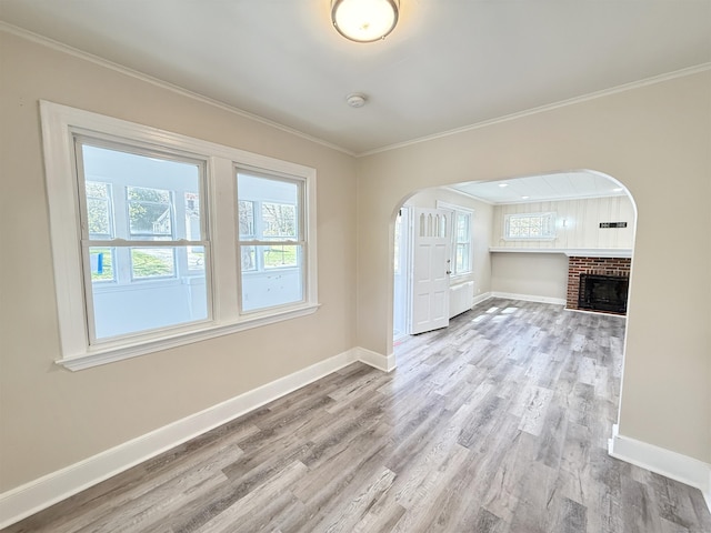 815 Alling Rd, Orange, CT 06477 - unfurnished living room featuring baseboards, healthy amount of natural light, wood finished floors, crown molding, and arched walkways