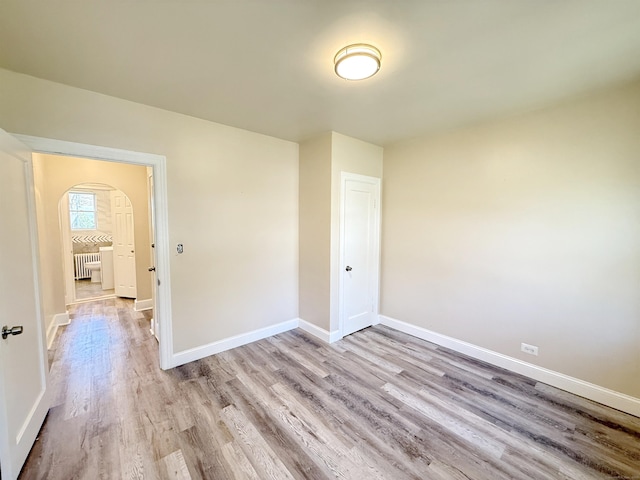 815 Alling Rd, Orange, CT 06477 - unfurnished room with arched walkways, light wood-style flooring, radiator heating unit, and baseboards
