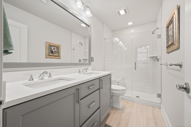 full bathroom with a stall shower, toilet, double vanity, and recessed lighting