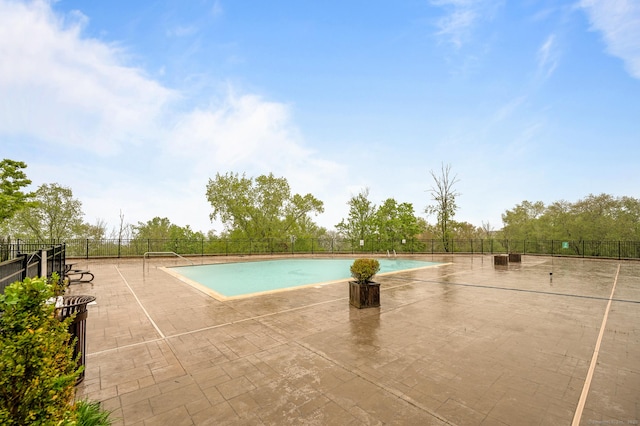 community pool featuring fence and a patio