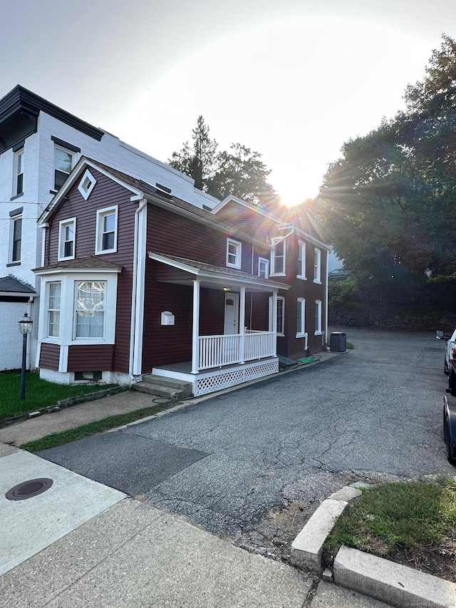 view of front of property featuring cooling unit and a porch
