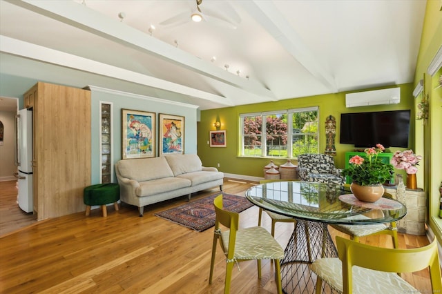 living room featuring an AC wall unit, light wood finished floors, ceiling fan, and baseboards
