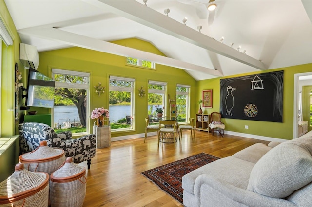 living area with vaulted ceiling, wood finished floors, a wall mounted air conditioner, and baseboards