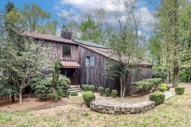 6 Kristy Dr, Bethel, CT 06801 - back of house with a chimney, roof mounted solar panels, and roof with shingles