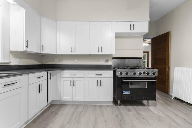 516 Savin Ave, West Haven, CT 06516 - kitchen with luxury range, radiator heating unit, white cabinets, and light wood-type flooring