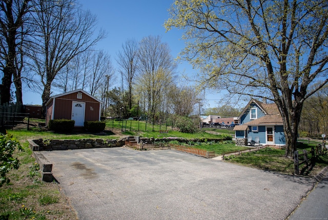 view of patio / terrace with a storage shed, an outbuilding, and fence