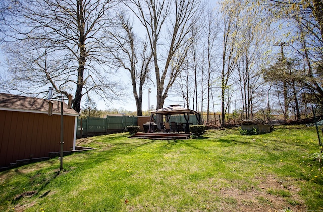view of yard featuring a gazebo, fence, a storage shed, and an outdoor structure