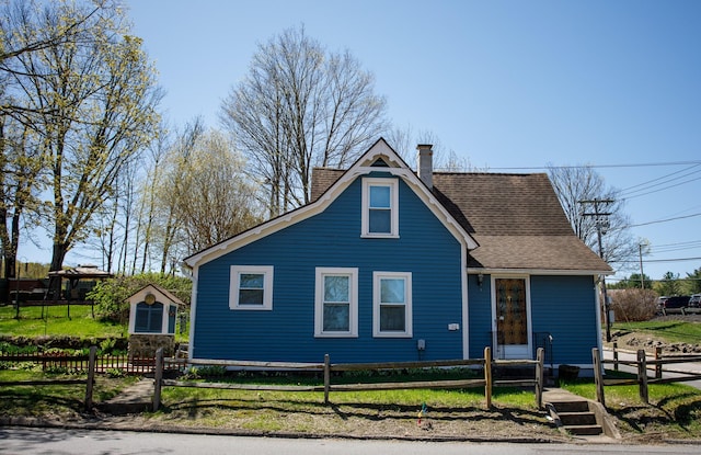 bungalow-style home featuring a chimney, roof with shingles, and a fenced front yard