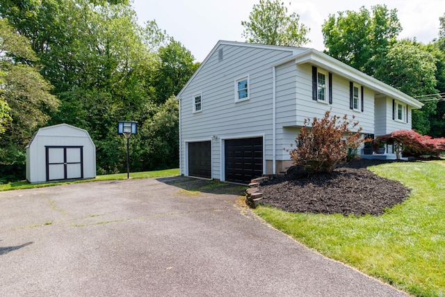 26 Sharon Cir, Meriden, CT 06450 - view of property exterior with a garage, a storage shed, driveway, and a yard